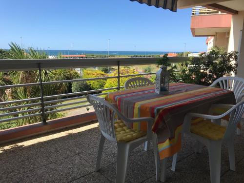 une table et des chaises sur un balcon avec vue sur l'océan dans l'établissement Hippocampe, à Anglet