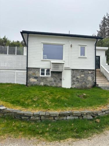 a white house with a window on top of a yard at Hytte på Bersagel in Sandnes