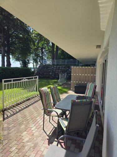 a patio with a table and chairs and a fence at Villa Seeschwalbe Plau in Plau am See