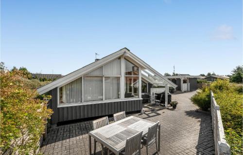 a house with a patio with a table and benches at Holiday Home Mosebøllevej Thisted Denm in Nørre Vorupør