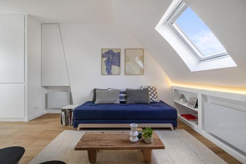 - une chambre avec un lit bleu et une lucarne dans l'établissement Miel, à Paris