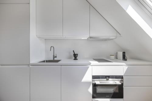 une cuisine blanche avec un évier et une cuisinière dans l'établissement Miel, à Paris