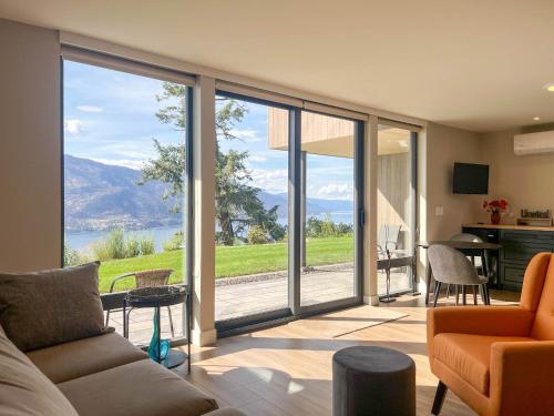 a living room with sliding glass doors with a view at Kelowfornia Lakeview Retreat in Kelowna