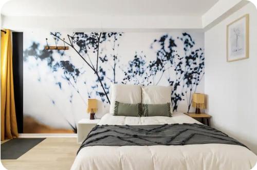 a bedroom with a bed with a blue and white wall at Les Cocons d AleXan Le studio balnéo aromathérapie in Quinssaines