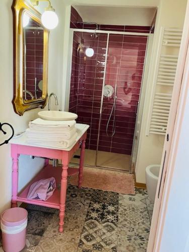a bathroom with a pink sink and a shower at La Vite è Bella in Govone