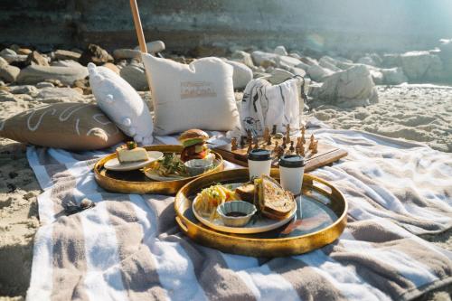 two plates of food on a blanket on the beach at Sonnekus Boutique Hotel & Bistro in Kalk Bay