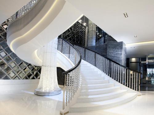 a spiral staircase in a building with a white stair case at Dorsett Tsuen Wan, Hong Kong in Hong Kong
