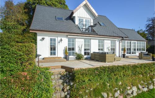 a white house with a stone wall at Three-Bedroom Holiday Home In Kolding in Kolding