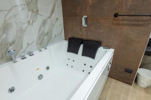 a white bath tub with two black pillows on it at San Giusto Rooms in Giardini Naxos