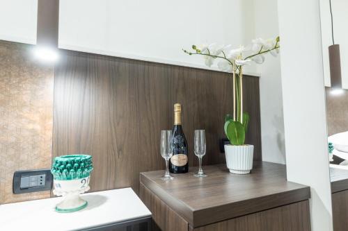 a kitchen with a counter with wine bottles and glasses at San Giusto Rooms in Giardini Naxos