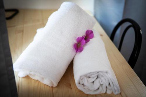 a white towel with purple flowers on a table at Hotel Milano Pool & Garden in Salice Terme