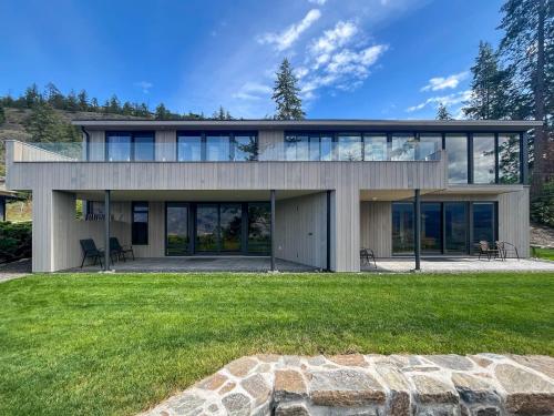 a house with large windows and a lawn at Kelowfornia Lakeview Retreat in Kelowna