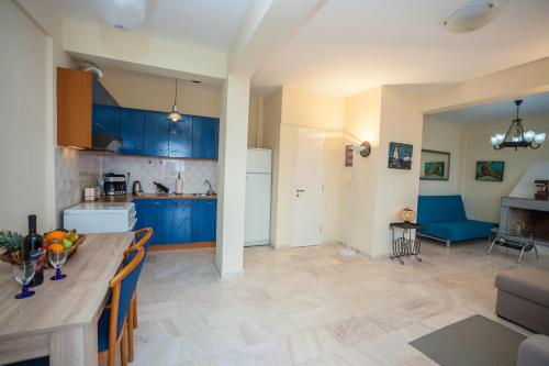 a kitchen and living room with blue cabinets and a table at Elounda Residence Resort & Waterpark in Elounda