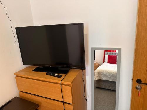 a flat screen tv sitting on top of a dresser at private room 6 in Bristol