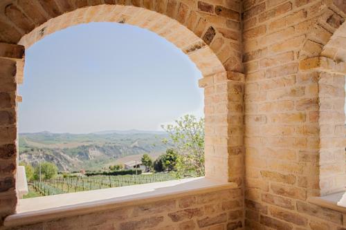 an arched window in a brick wall with a view at La Terrazza sul Vigneto in Offida