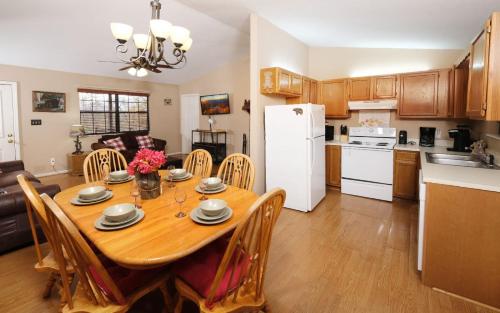 a kitchen and dining room with a wooden table and a white refrigerator at Serenity in Pigeon Forge