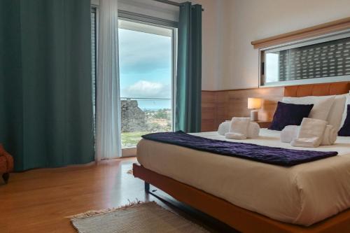 Un dormitorio con una cama grande con una ventana grande. en Bio Vida, en São Vicente Ferreira