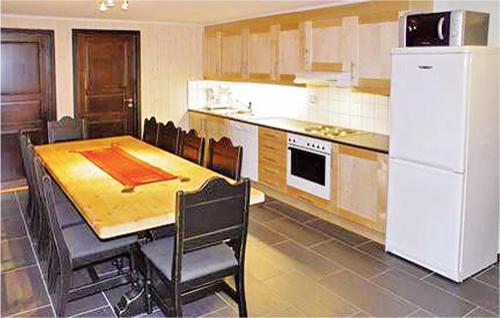 ヘムセダールにあるGorgeous Apartment In Hemsedalのテーブルと白い冷蔵庫のあるキッチン