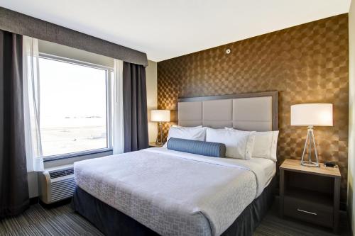 a hotel room with a large bed and a window at Canalta Kindersley in Kindersley