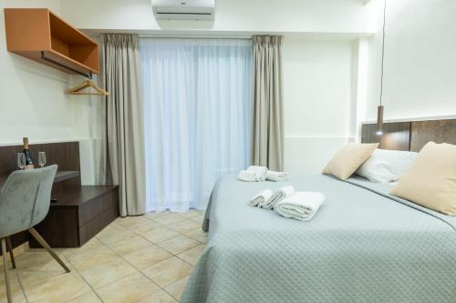 a hotel room with two beds and a desk at San Giusto Rooms in Giardini Naxos