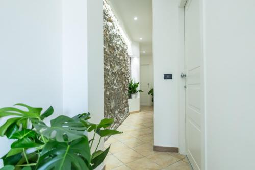 a hallway with plants and a door at San Giusto Rooms in Giardini Naxos