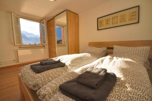 ein Schlafzimmer mit 2 Betten und Handtüchern darauf in der Unterkunft Seegärtli Riverside Apartment in Goldswil