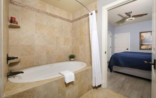 a bathroom with a bath tub and a bed at The Smoky Mountain Nest in Pigeon Forge
