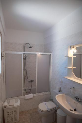 a bathroom with a shower and a toilet and a sink at Elounda Residence Resort & Waterpark in Elounda