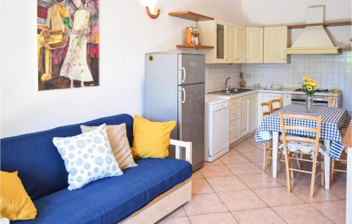 a living room with a blue couch and a kitchen at Agriturismo Le Cannelle in Pieve di Santa Luce