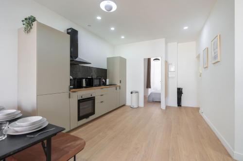 Il comprend une cuisine avec des murs blancs et du parquet. dans l'établissement Vieux-Port Gare St Charles le Massilia, à Marseille