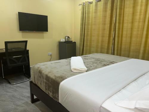 a bedroom with a bed and a flat screen tv at The wish executive lodge in Kafue