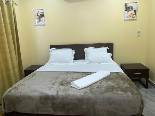 a bedroom with a bed with two towels on it at The wish executive lodge in Kafue