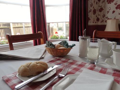 a table with a plate with a loaf of bread on it at The Corner House in Lowestoft