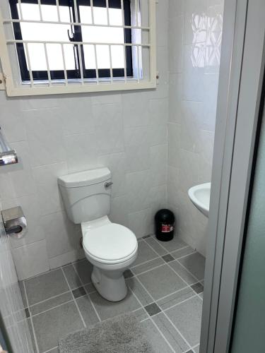 a bathroom with a white toilet and a sink at The wish executive lodge in Kafue