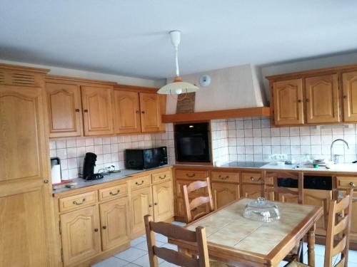une cuisine avec des armoires en bois et une table en bois dans l'établissement tranquillite, à Lavaudieu