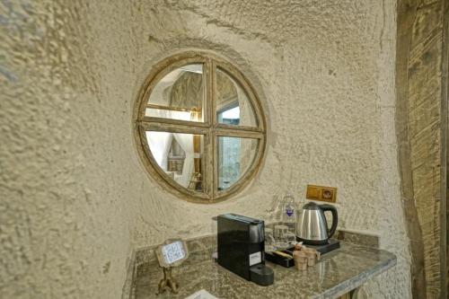 a mirror on a wall with a counter with a microwave at Wish Cappadocia in Uchisar