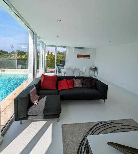 a living room with a black couch and a pool at White Beach Villa in Sagres