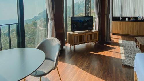 a living room with a television and a table and chairs at Damar Langit Resort in Cisarua