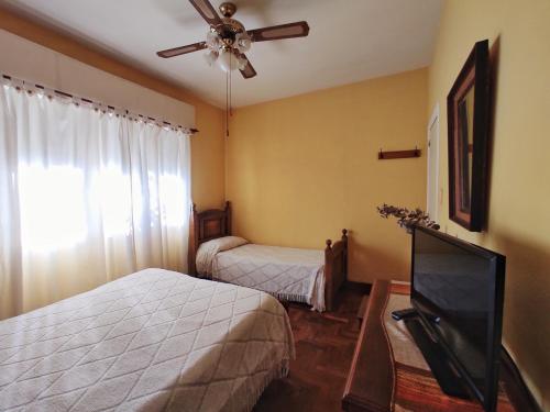 a bedroom with two beds and a flat screen tv at Alquiler de casa temporario en Suipacha "Lo de Juancho" in Suipacha