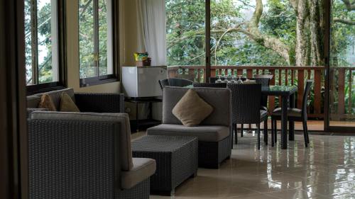 a dining room with a table and chairs and windows at Damar Langit Resort in Cisarua