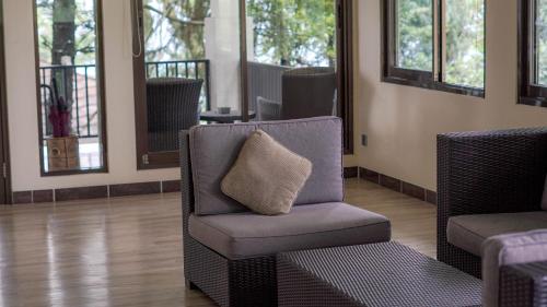 a chair with a pillow in a room with windows at Damar Langit Resort in Cisarua