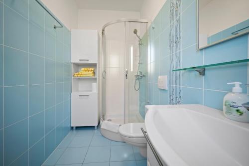 a blue bathroom with a toilet and a shower at House , Seafront Apartment Pelegrin in Stomorska