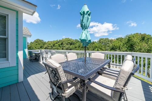 a table and chairs on a deck with an umbrella at Family Tradition in Duck
