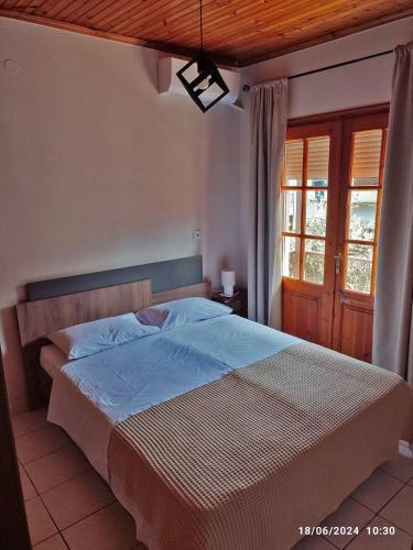 a bedroom with a large bed with a wooden ceiling at Geothan's House in Skala Sotiros