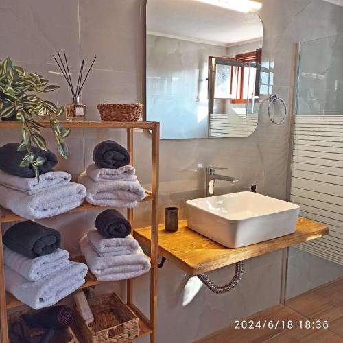 a bathroom with a sink and towels on a shelf at Geothan's House in Skala Sotiros