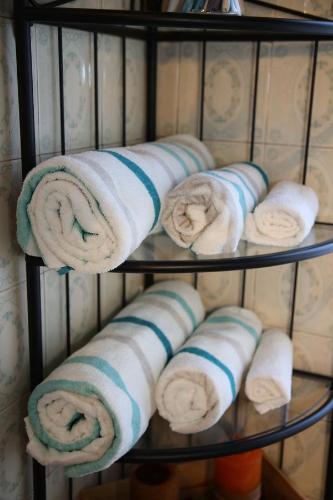 a bunch of towels are on a shelf at Bilocale Indipendente in Milan