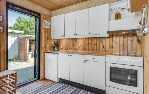 a kitchen with white cabinets and a stove at Three-Bedroom Holiday Home In Follenslev in Føllenslev