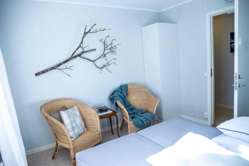 a bedroom with a bed and two chairs and a table at Hunnebostrands vandrarhem Gammelgården in Hunnebostrand
