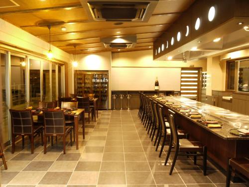 um restaurante com um longo bar com mesas e cadeiras em Misakitei em Kami Amakusa