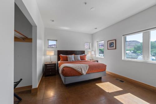 a bedroom with a bed and two windows at 57 Robber's Roost in Moab